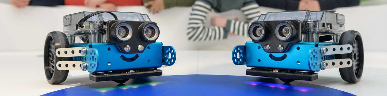 Zwei blaue Mbot-Roboter mit Rädern