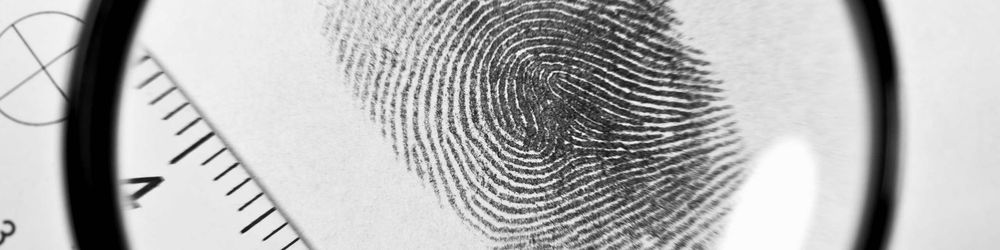 Ein Fingerabdruck wird durch eine Lupe vergrößert