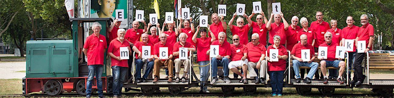 Foto: Ehrenamtliche stehen vor der Feldbahn und halten Buchtstaben in die Luft, die den Schriftzug "Ehrenamt macht stark" ergeben, Ehrenamtliche stehen vor der Feldbahn und halten Buchtstaben in die Luft, die den Schriftzug "Ehrenamt macht stark" ergeben,