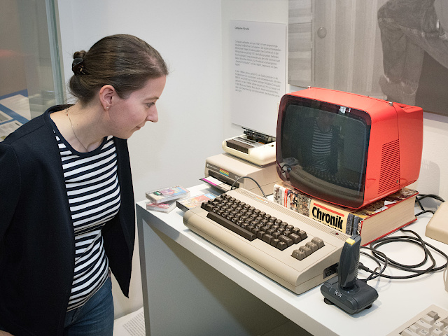 Foto einer Besucherin, die einen alten Computer betrachtet