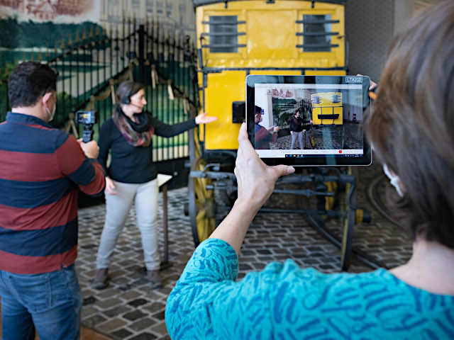 Eine Frau filmt mit einem Tablet eine Online-Führung im Museum