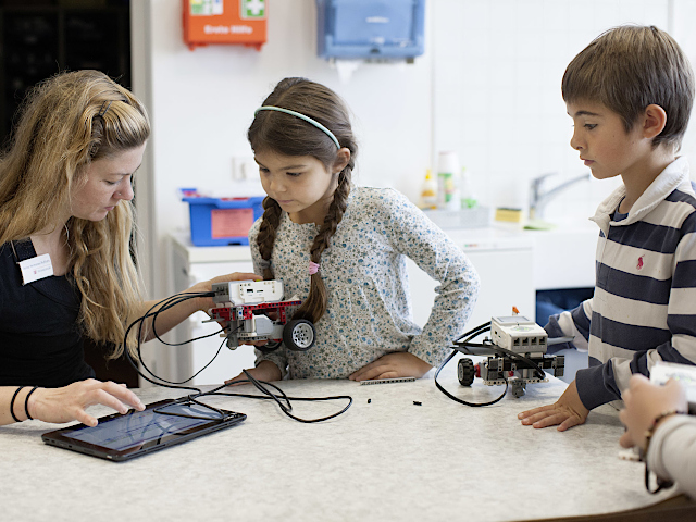 Foto von Kindern, die mit Lego-Robotern experimentieren